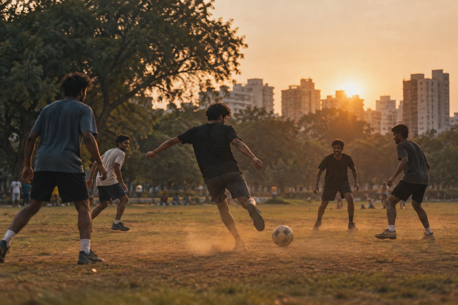 Friends playing football in a city park in the early evening light.